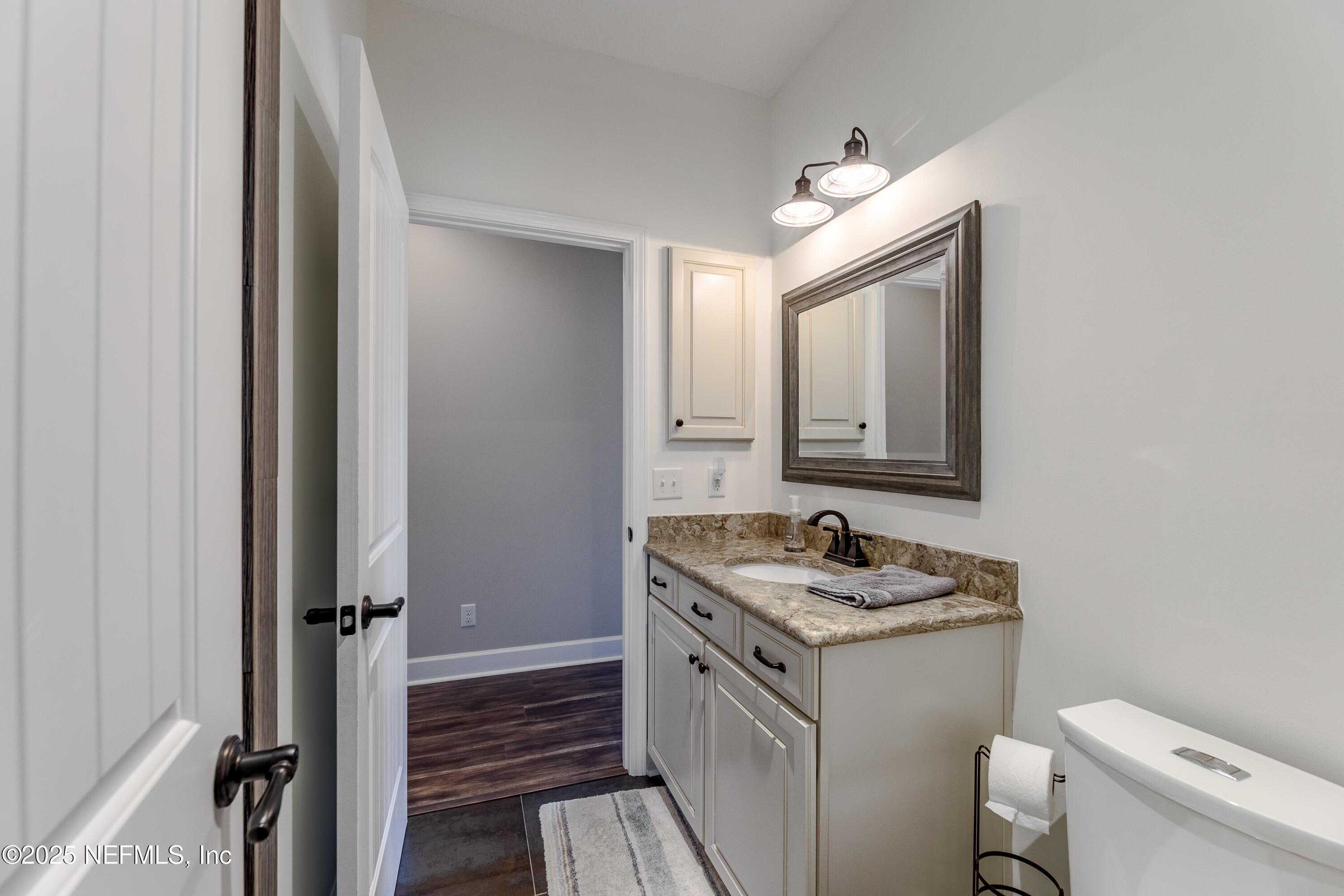 3670 Charles Green Road Hilliard, FL 32046 - Photo 42 of 68 a bathroom with a granite countertop sink toilet and a mirror