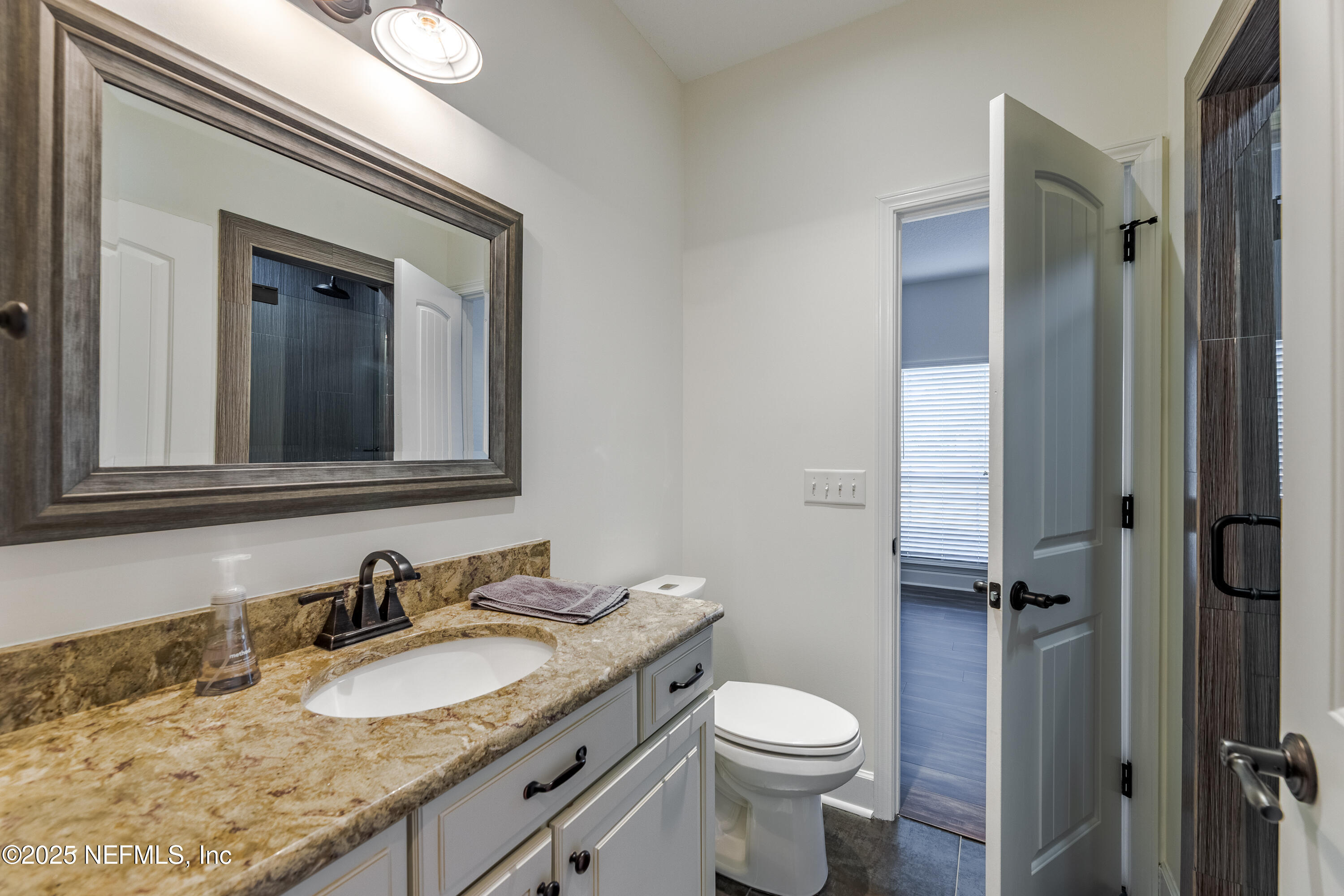 3670 Charles Green Road Hilliard, FL 32046 - Photo 43 of 68 a bathroom with a granite countertop sink toilet and shower