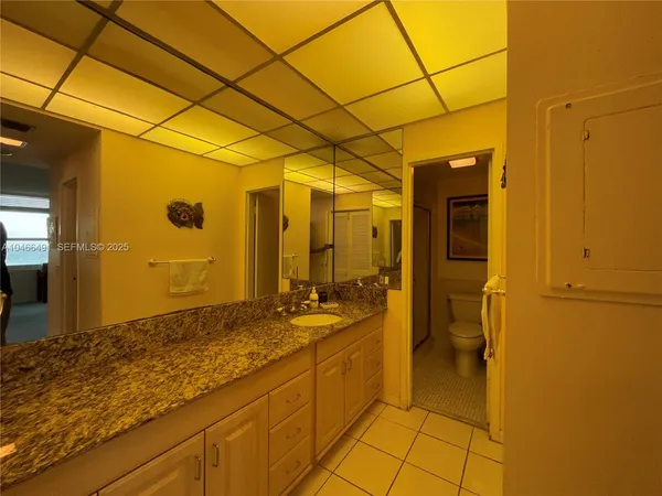 a bathroom with a granite countertop sink and a mirror