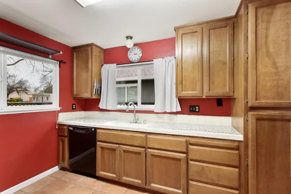 a en suite bathroom with a granite countertop double vanity sink a window and a mirror