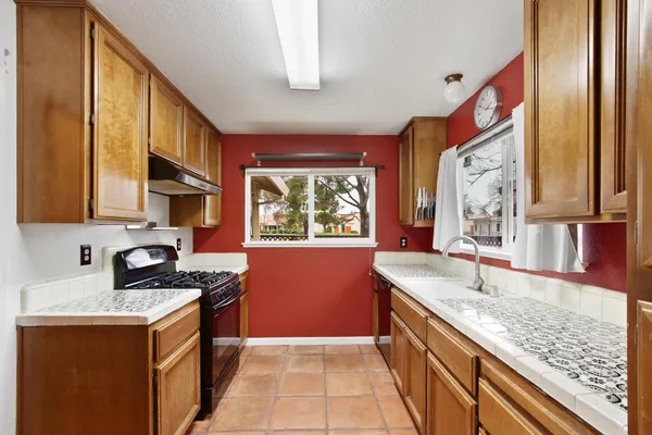 a kitchen with granite countertop sink stove and cabinets