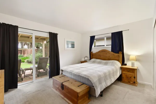 a bedroom with a bed lamp and a large window