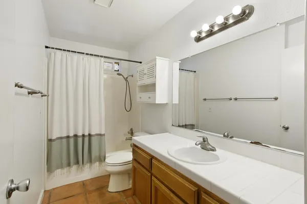 a bathroom with a sink a toilet a mirror and shower