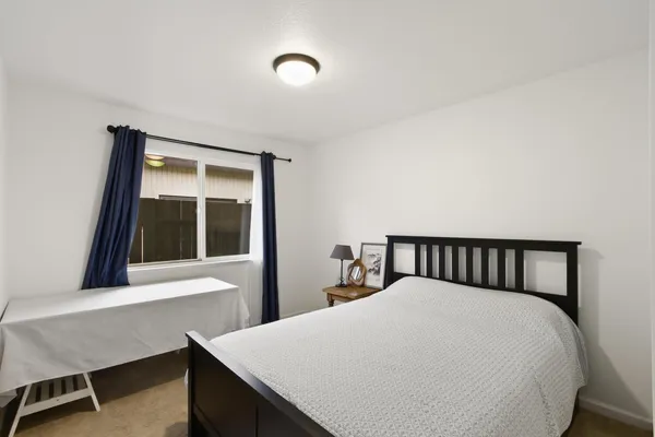 a bed sitting in a bedroom next to a window