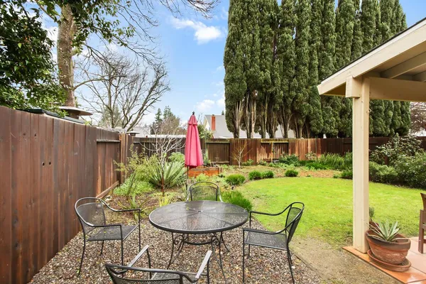 a view of a chair and table in backyard of the house
