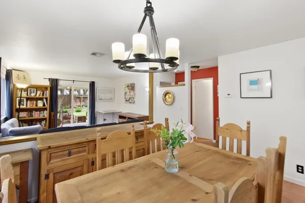 a dining room with wooden floor and chandelier