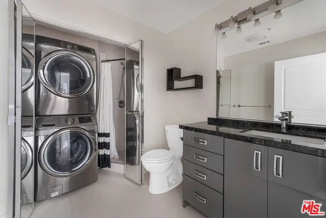 a bathroom with a granite countertop toilet sink and mirror