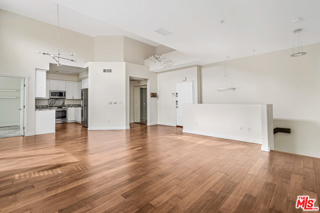 13044 Pacific Promenade, Unit 417 Playa Vista, CA 90094 - Photo 5 of 31 a view of a kitchen with a fridge and wooden floor