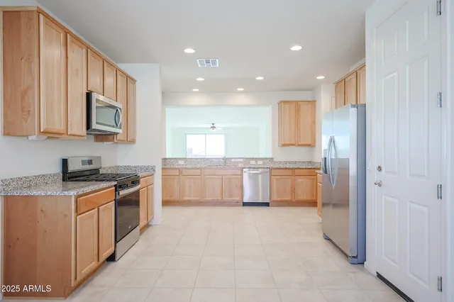 a kitchen with stainless steel appliances granite countertop a stove a sink and a refrigerator