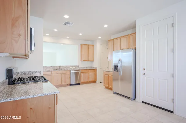 a kitchen with granite countertop a sink a counter and stainless steel appliances