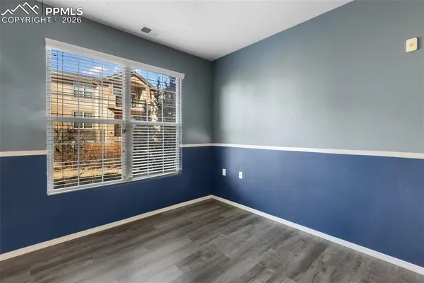 a view of an empty room with wooden floor