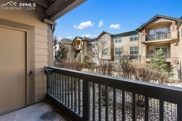 a view of a balcony with wooden fence and two windows