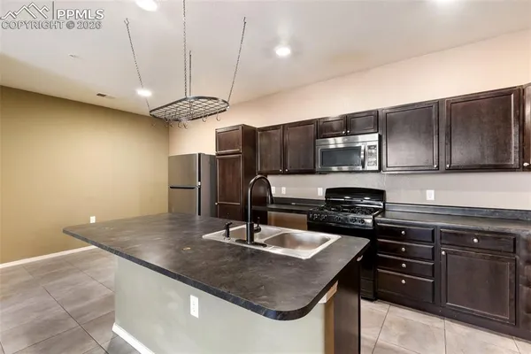 a kitchen with stainless steel appliances granite countertop a sink a stove and microwave