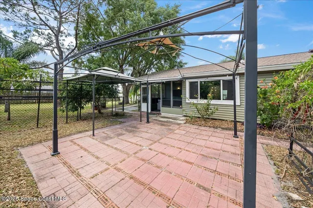 a backyard of a house with basket ball table and chairs