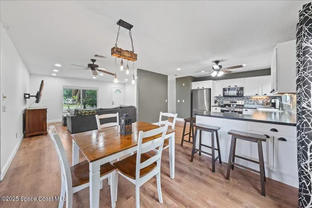 a kitchen with kitchen island a dining table and chairs
