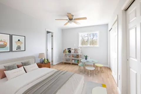 an empty room with wooden floor a ceiling fan and windows