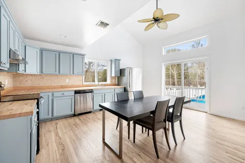 a kitchen with a dining table chairs and white cabinets