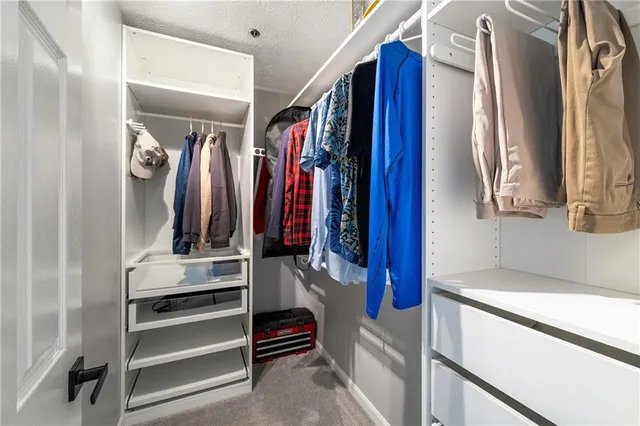 a view of walk in closet with clothes and shoes