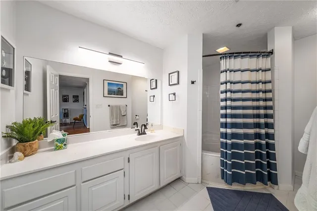 a bathroom with a double vanity sink mirror and shower