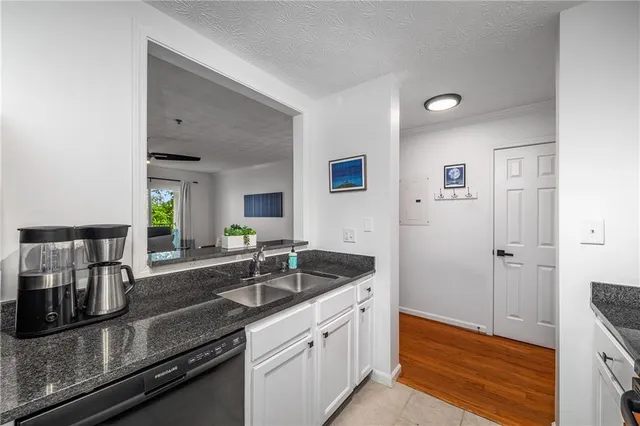 a kitchen with granite countertop a sink and cabinets