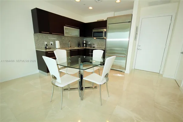 a kitchen with stainless steel appliances granite countertop a refrigerator a stove a sink and a microwave
