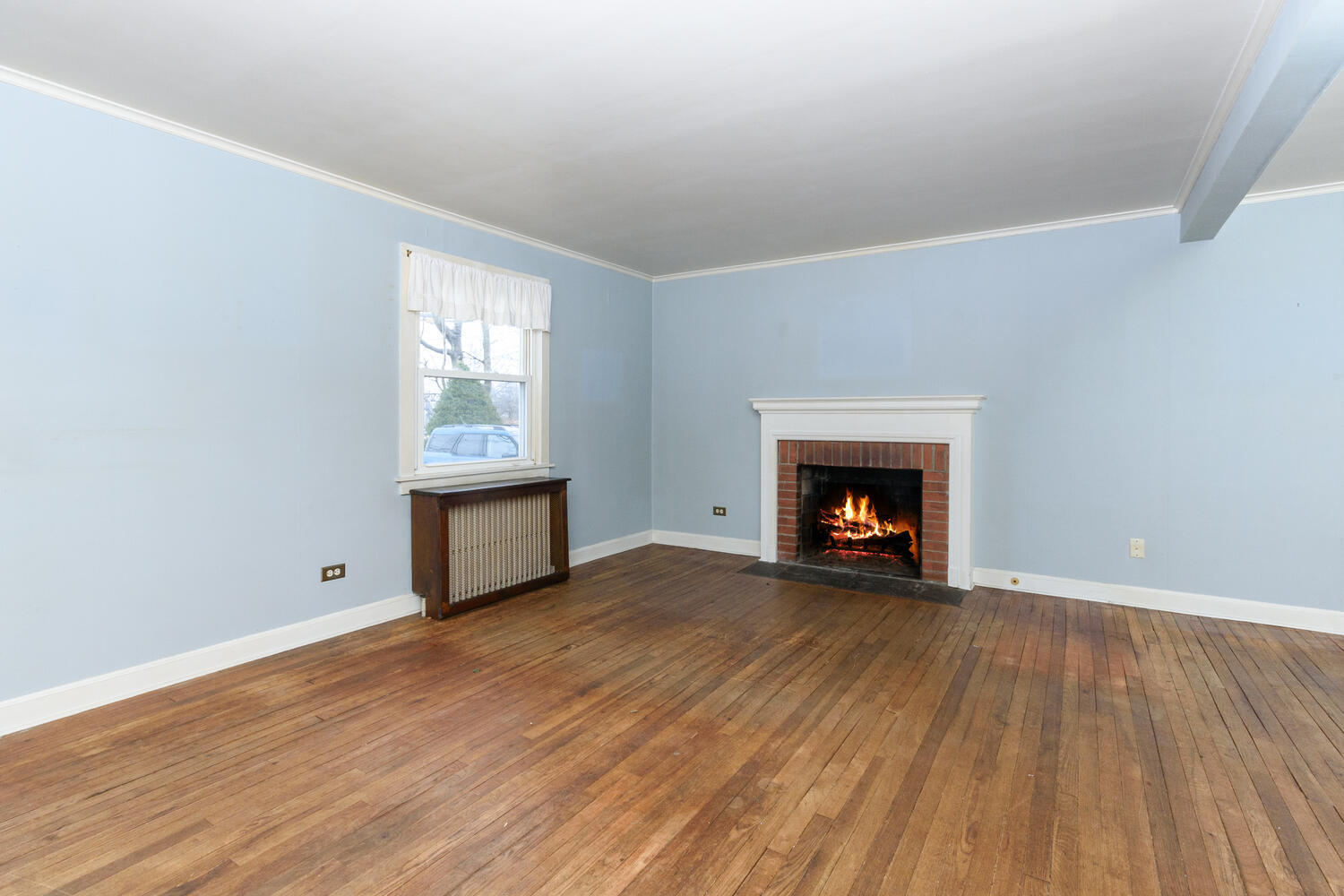 159 Hollow Tree Ridge Road Darien, CT 06820 - Photo 4 of 20 a view of an empty room with wooden floor fireplace and a window