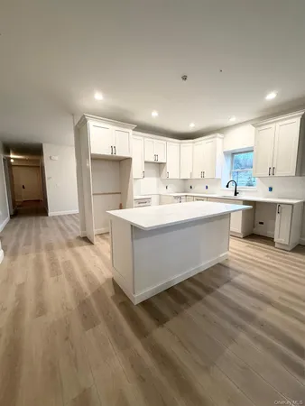 a large white kitchen with white cabinets and white appliances