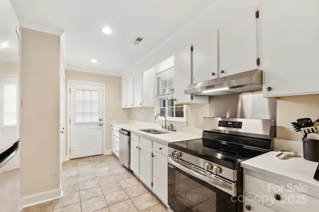 a kitchen with stainless steel appliances a stove a sink and a refrigerator