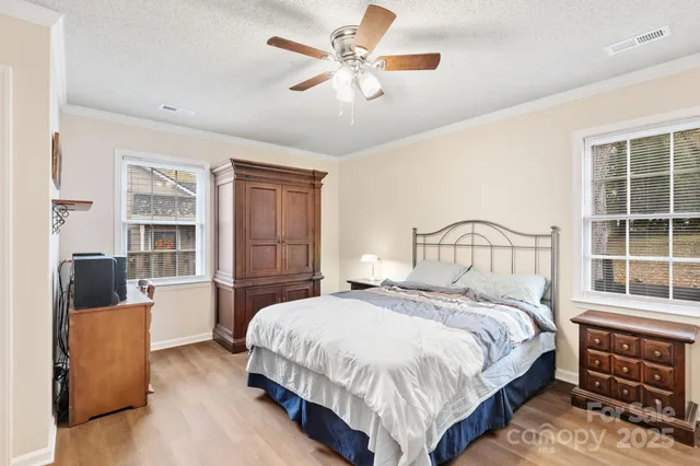 a bedroom with a bed a dresser and a chandelier