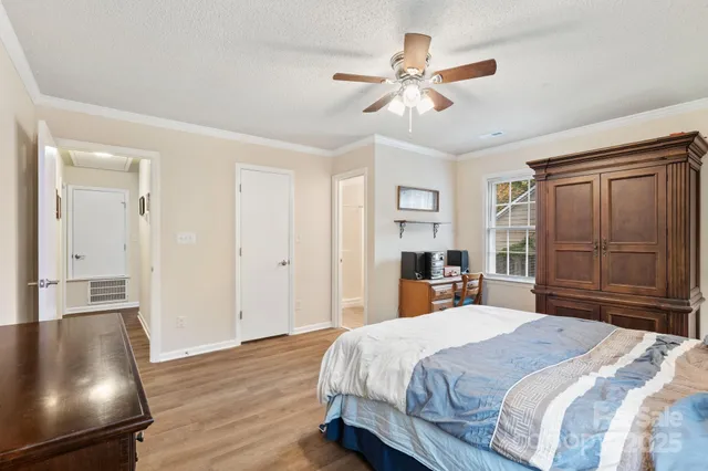a bedroom with a large bed and a chandelier