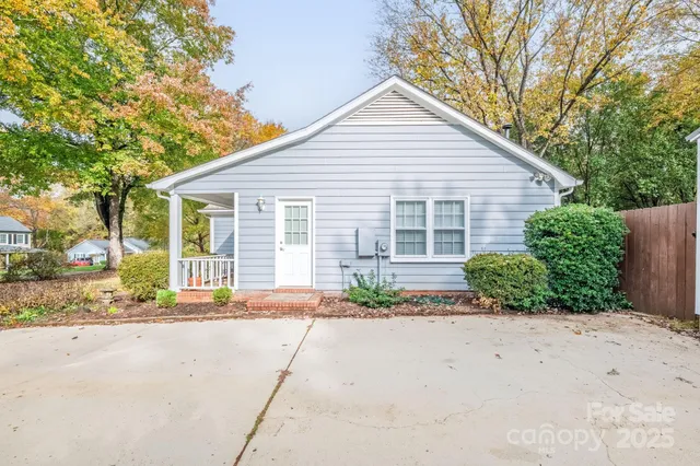 a front view of a house with a yard and potted plants
