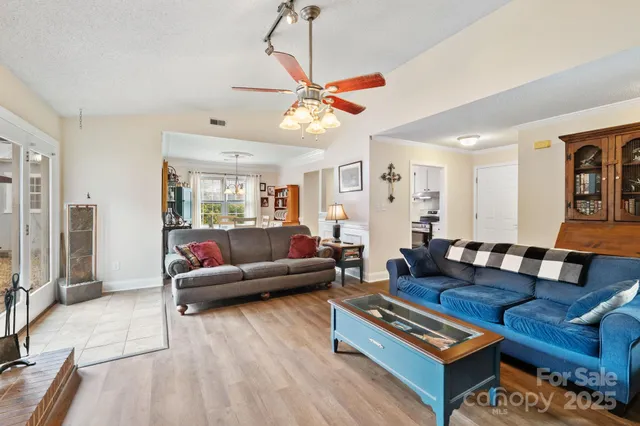 a living room with furniture a wooden floor and a chandelier
