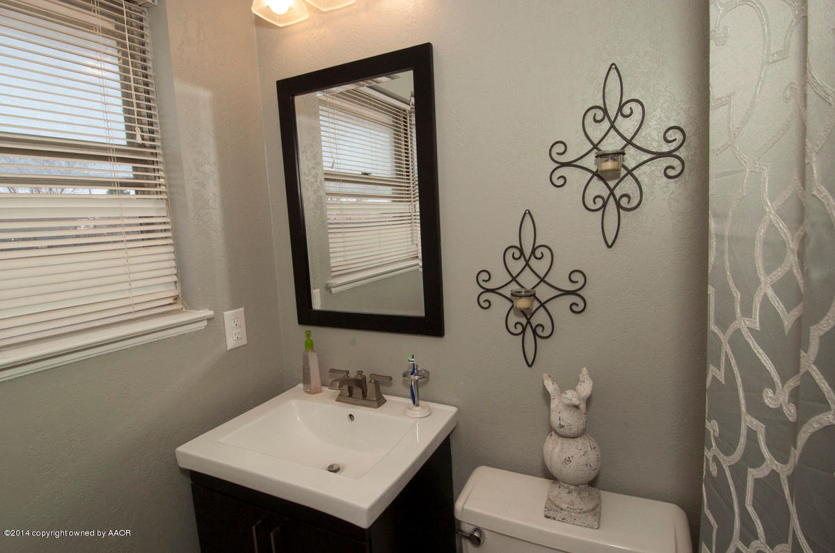 2607 Darrell Avenue Amarillo, TX 79110 - Photo 17 of 28 a bathroom with a toilet sink and mirror