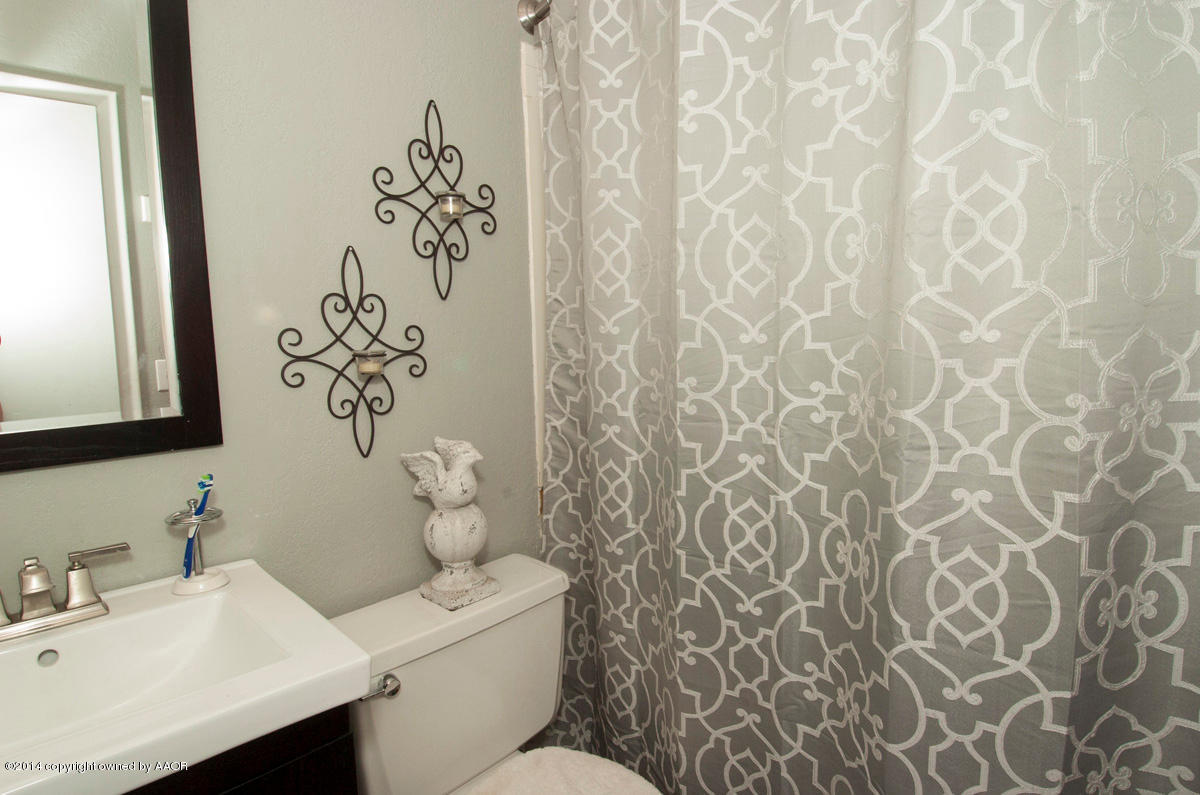 2607 Darrell Avenue Amarillo, TX 79110 - Photo 18 of 28 a bathroom with a toilet sink and mirror