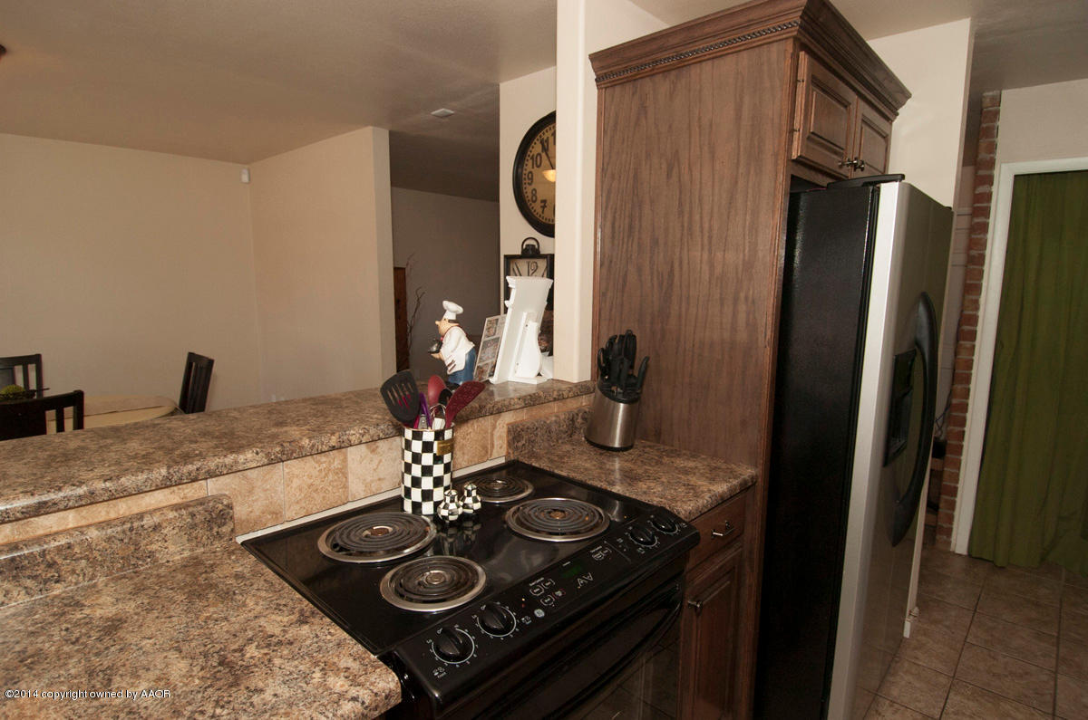 2607 Darrell Avenue Amarillo, TX 79110 - Photo 10 of 28 a kitchen with stainless steel appliances granite countertop a sink stove and refrigerator