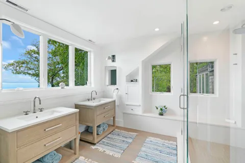 a bathroom with a double vanity sink mirror and window