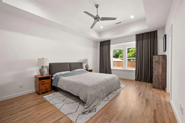 a bedroom with a large bed chandelier and a window