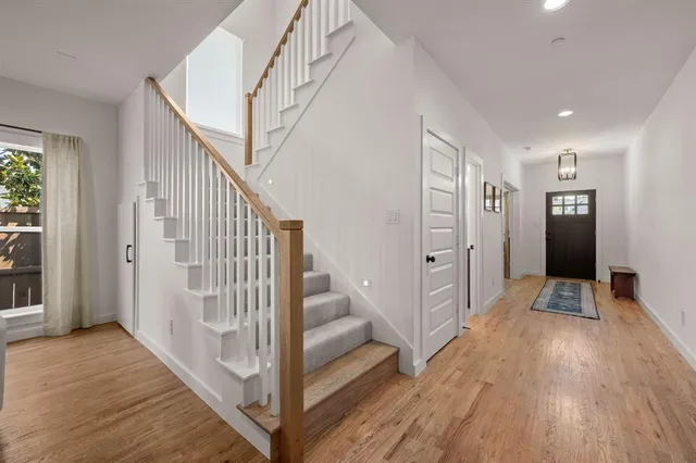 a view of a hallway with wooden floor and staircase