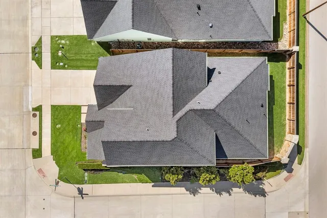 an aerial view of a house with a yard and large tree