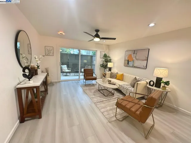 a living room with furniture a rug and a floor to ceiling window