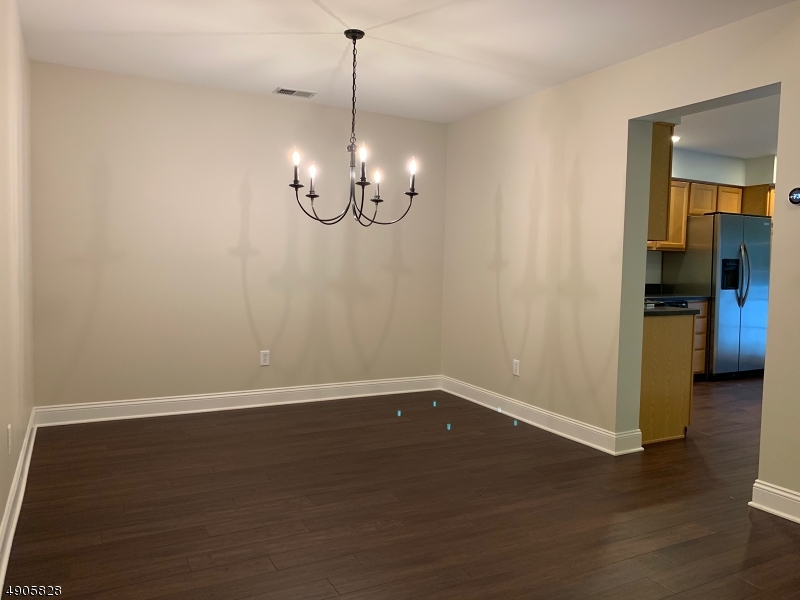 105 Well Sweep Road, Unit 105 Whitehouse Station, NJ 08889 - Photo 3 of 22 a view of a room with wooden floor chandelier and windows