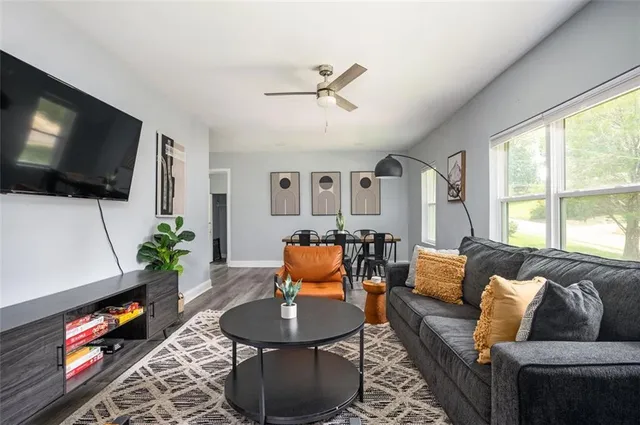 a living room with furniture a flat screen tv and a window