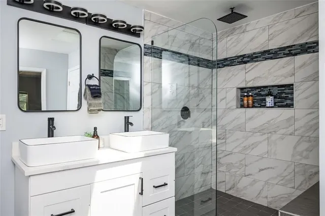 a bathroom with a sink mirror and shower