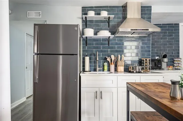 a kitchen with stainless steel appliances granite countertop a refrigerator and a sink