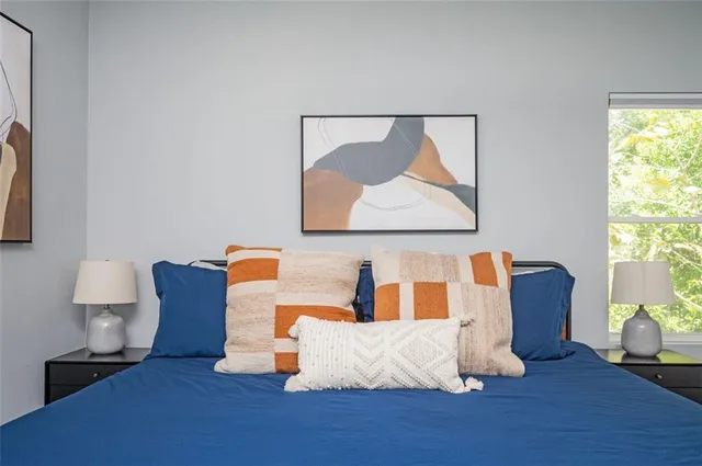 a white bed sitting in a bedroom next to a window