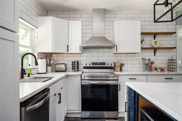 a kitchen with stainless steel appliances granite countertop a sink stove and cabinets