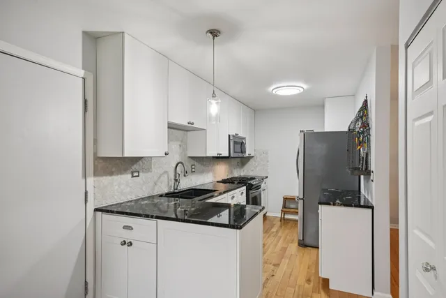 a kitchen with stainless steel appliances granite countertop a refrigerator a stove a sink and a refrigerator