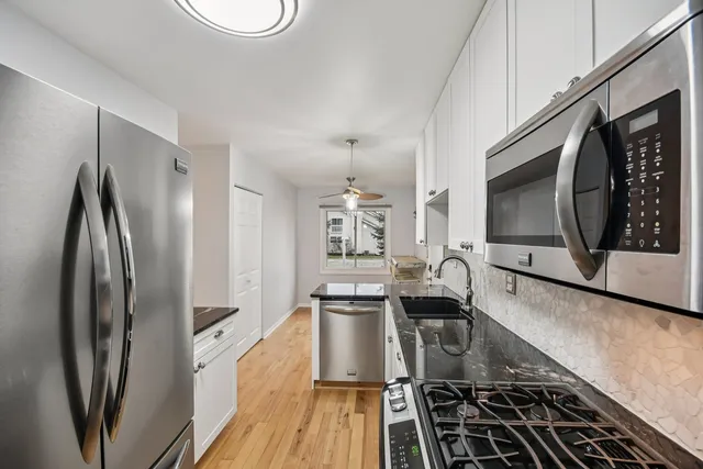 a kitchen with stainless steel appliances a stove a sink and a microwave