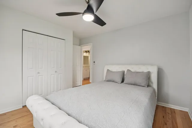 a bed room with a bed and a ceiling fan