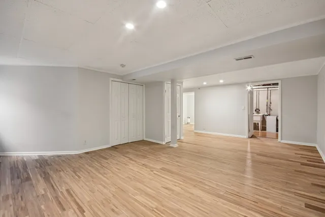 a view of an empty room with wooden floor